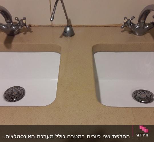 שני כיורים עם ברזים כפולים על משטח שיש